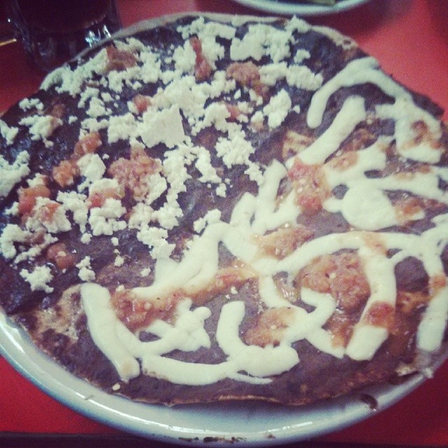 a white plate topped with a chocolate pizza covered in toppings