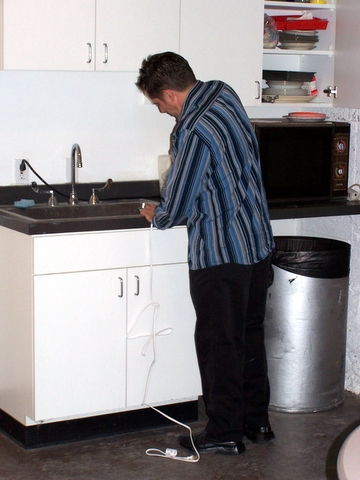 a man is washing dishes in a kitchen