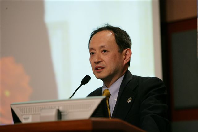 a man in a suit speaking on stage