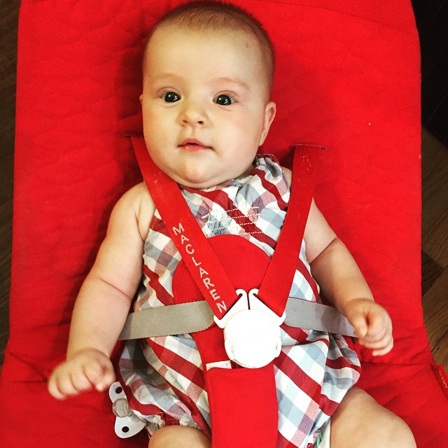 a small baby wearing a red and white dress
