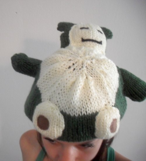 a woman wearing a knitted beanie with a stuffed animal