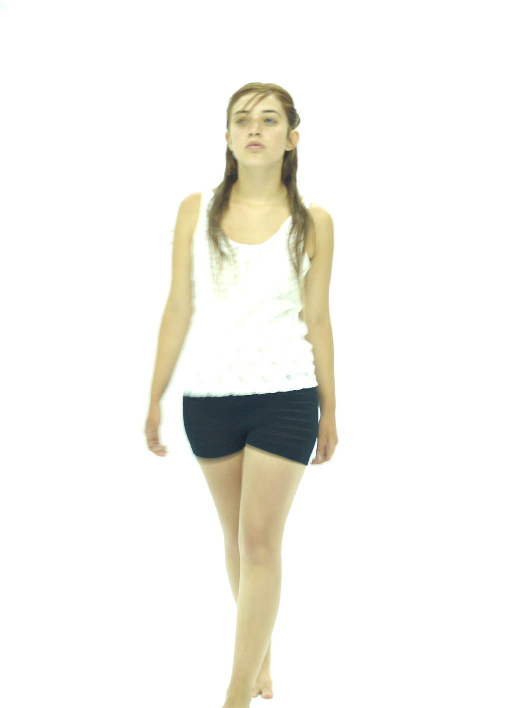 a woman with long hair standing and wearing shorts