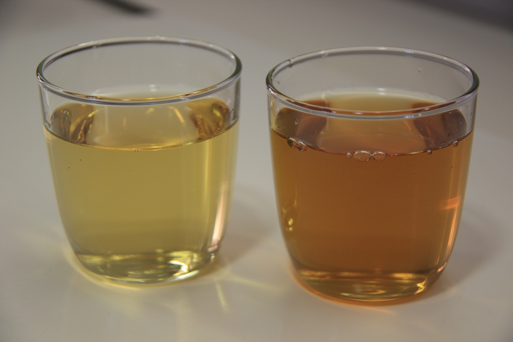 two glasses are filled with liquid on a table