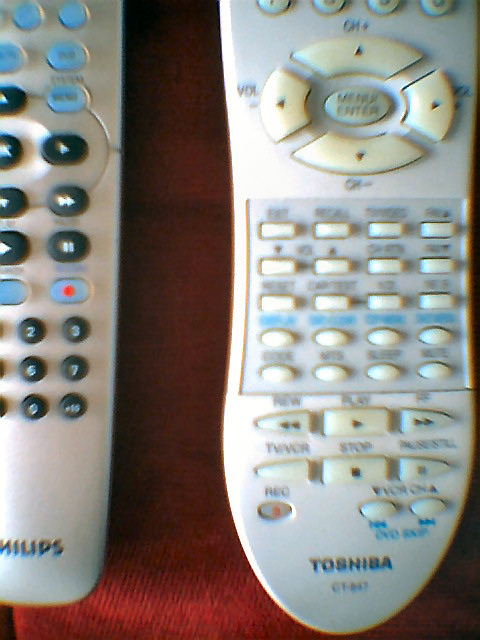 two video game remote controls sitting side by side