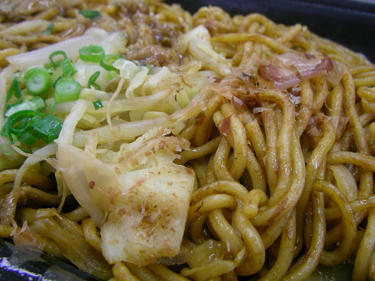 a dish of noodles with shrimp and vegetables