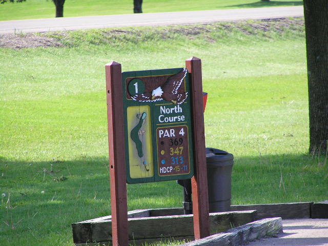 a sign for north course is on the grass