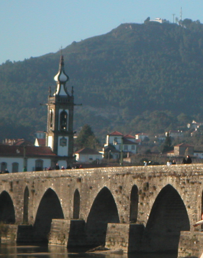 a bridge that has arches in front of mountains