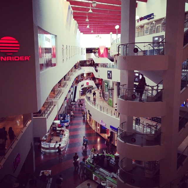 an indoor shopping mall with people walking inside