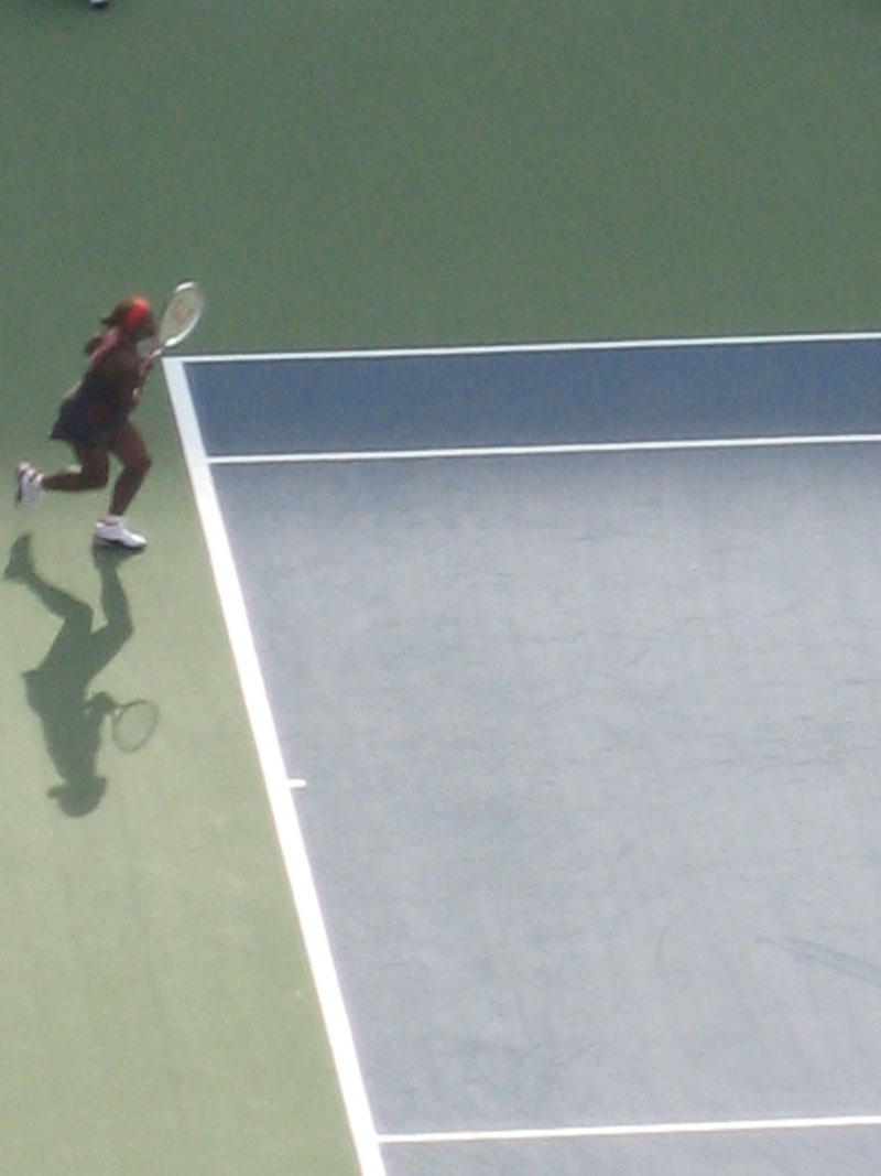 a person is running and playing tennis on a court