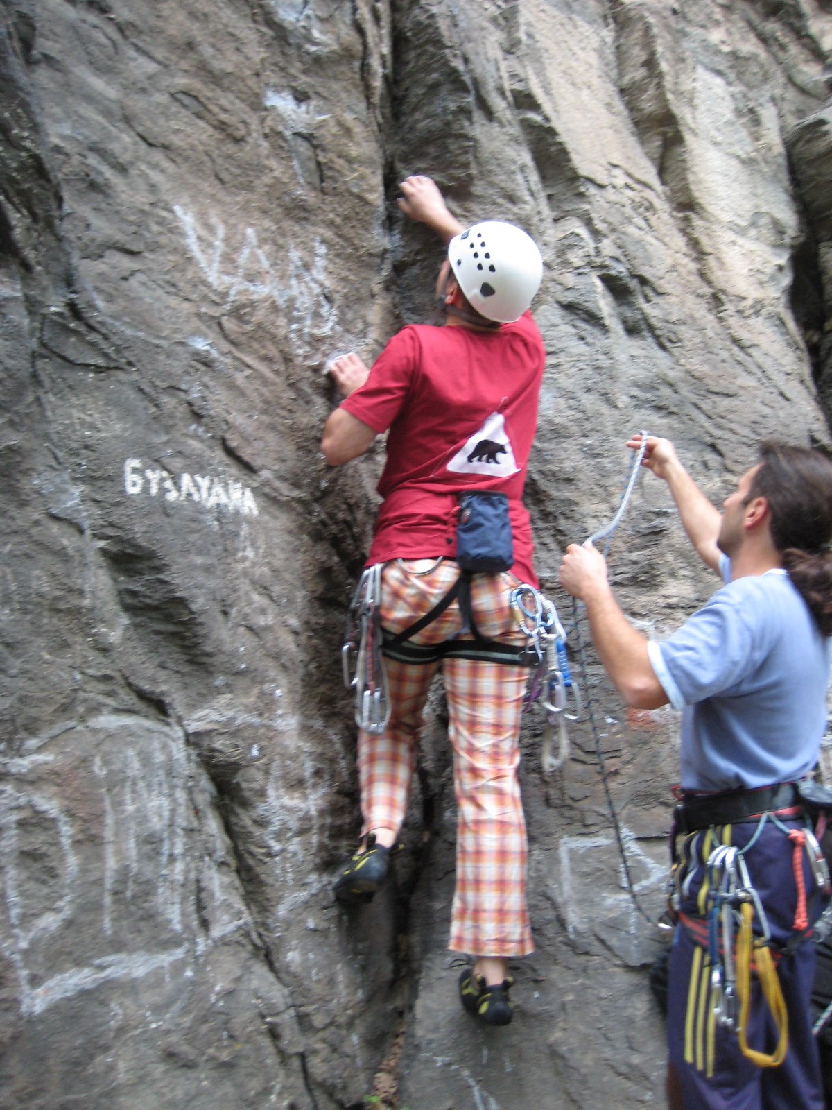 two climbers climb up the side of a mountain