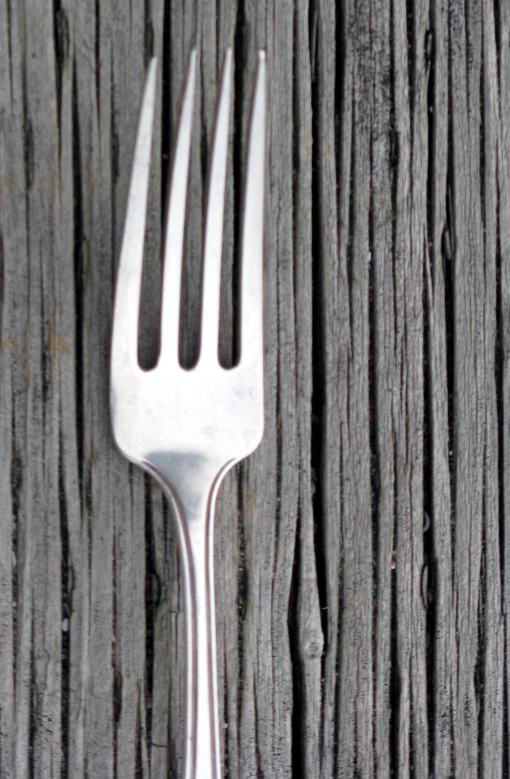 a fork leaning against the edge of a wooden wall