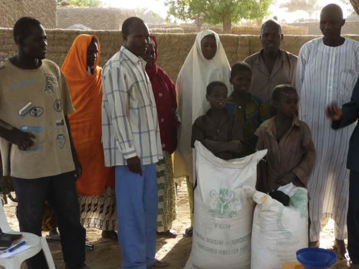 a group of people standing around bags of food