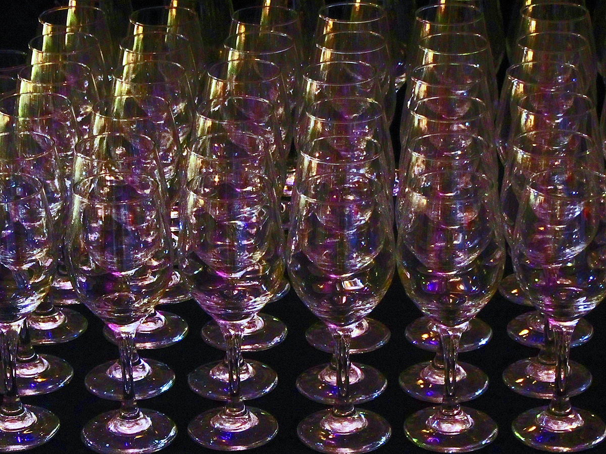 many champagne flutes stacked up in the dark