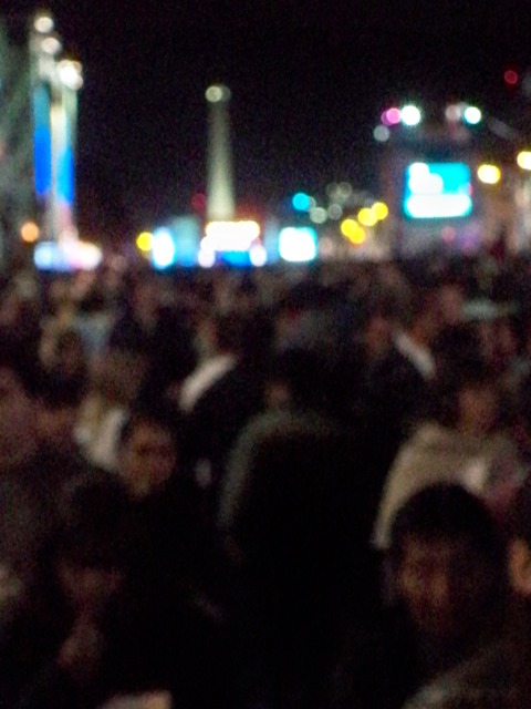 a large crowd of people in the city at night