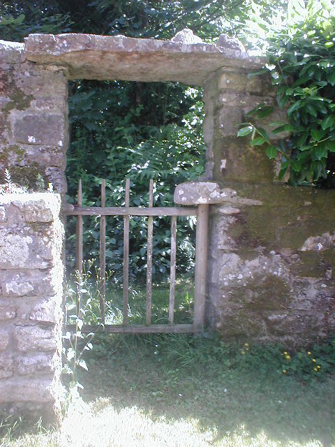 an old stone fence with an old gate in it