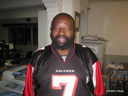 man in uniform with black and red football jersey in office