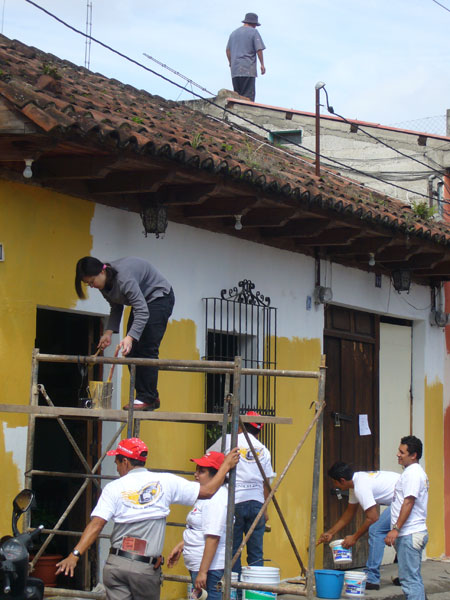 a group of men working together on a roof