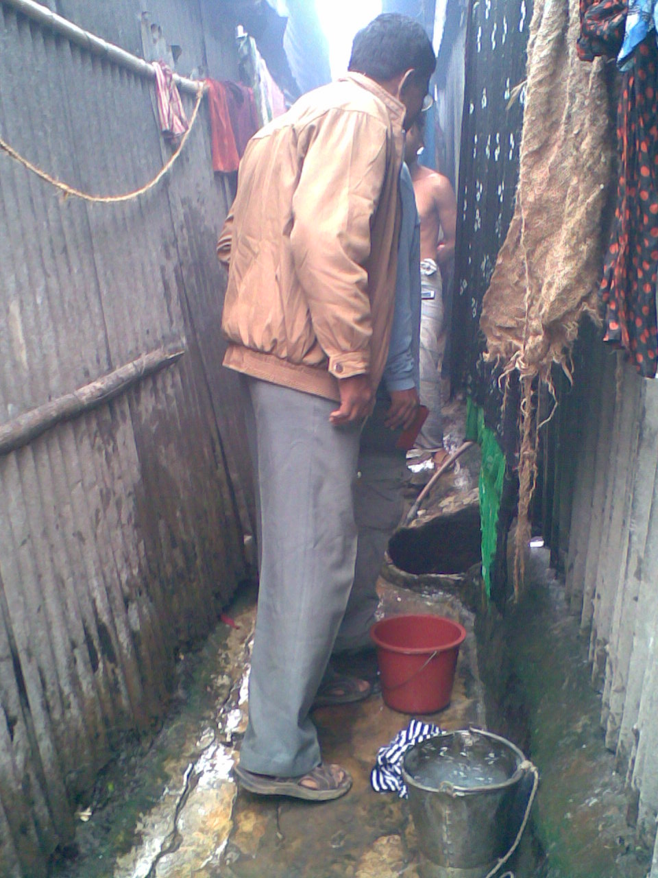 people washing clothes on a dirty street