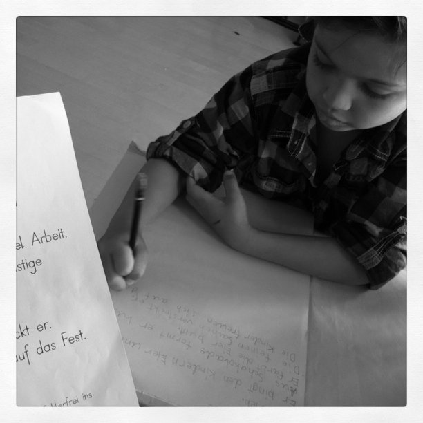 the boy is writing a handwritten message with a pen