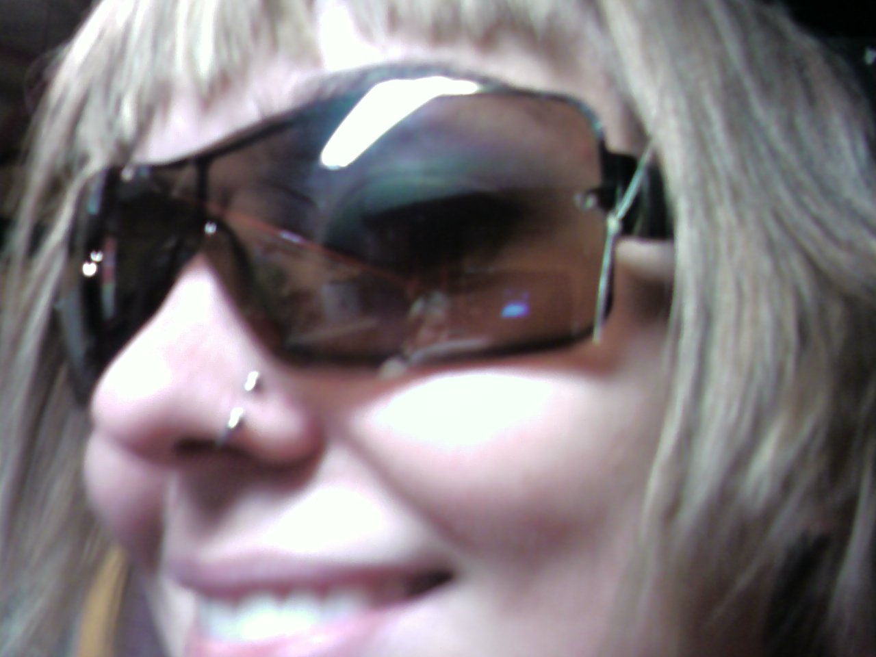 a lady with shiny shades and nose piercing