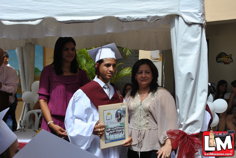 two women and a man are dressed in graduation attire