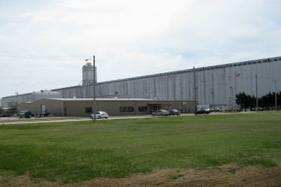 an industrial plant with cars parked in the front yard