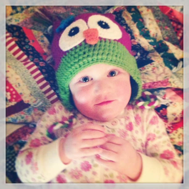 an adorable little girl wearing a knit owl hat