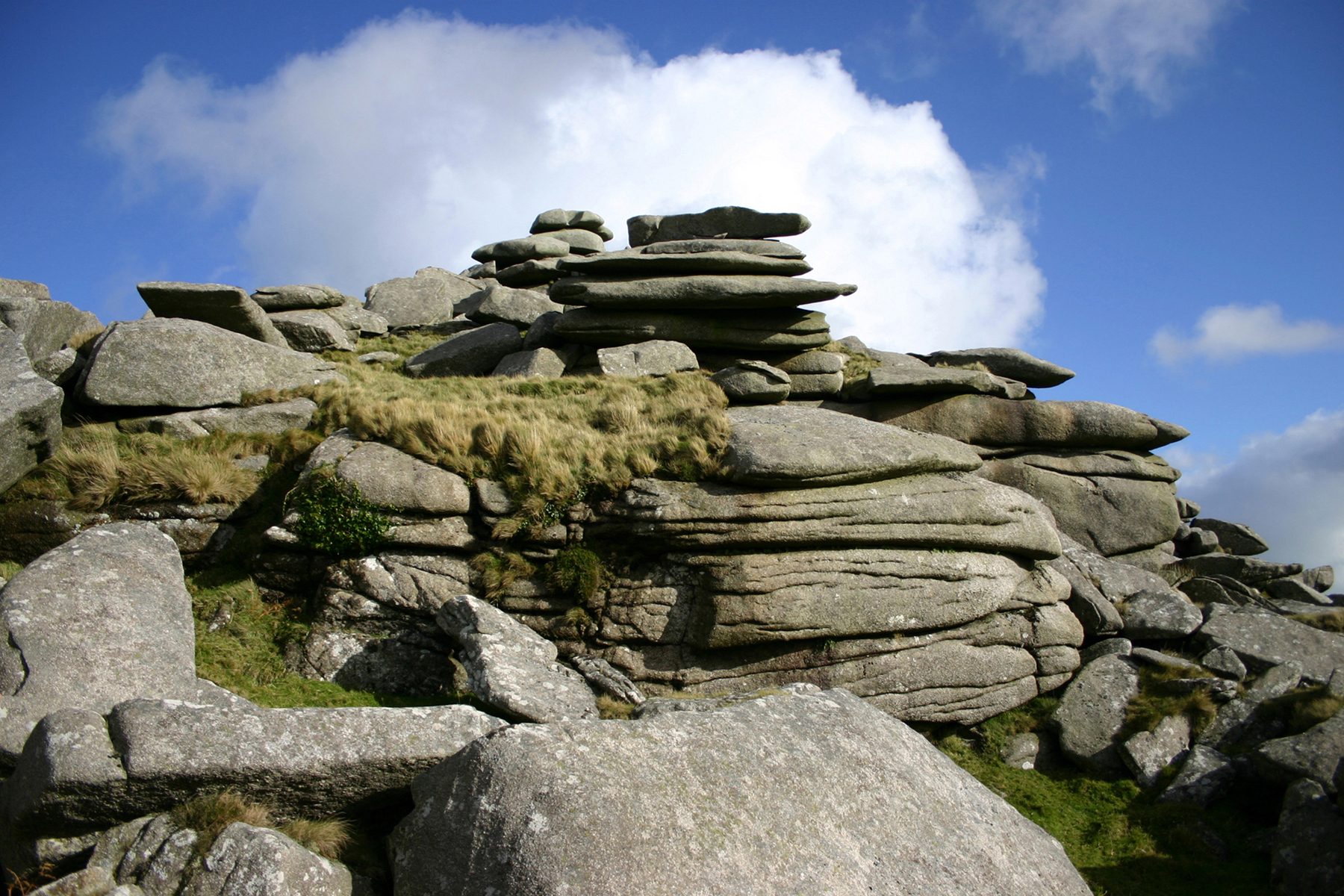 rocks piled into a pyramid near grass