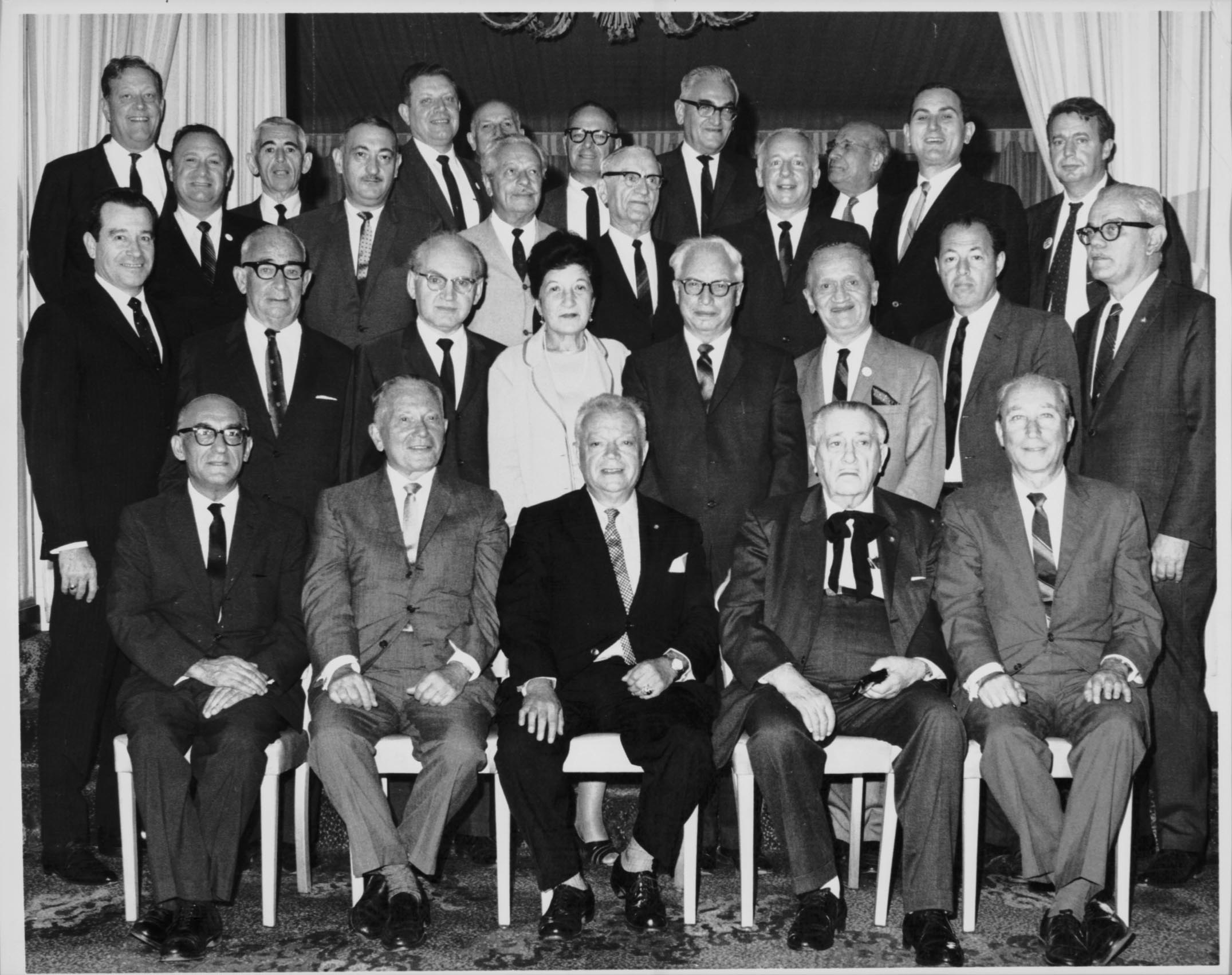 the group of people in suits are sitting together