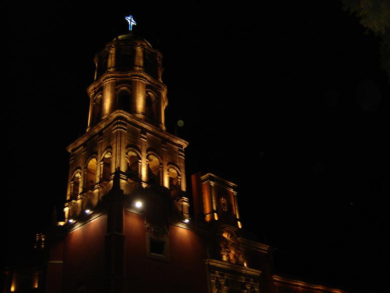 an upward view of a clock tower lit up at night