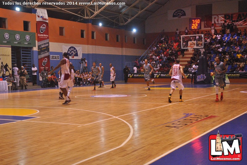 a group of people playing basketball in a large gymnasium