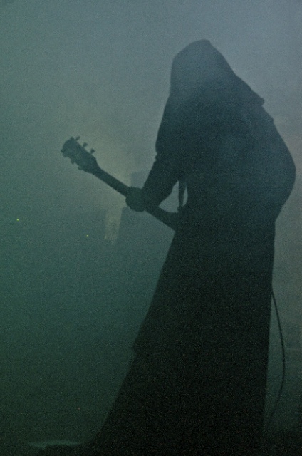 a woman holding an acoustic guitar and a microphone in the fog