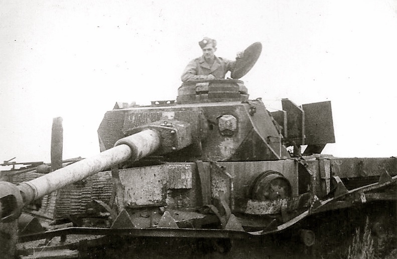 a man in uniform sitting on a large tank