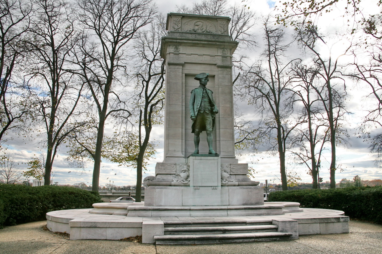 a white monument surrounded by trees and a blue sky