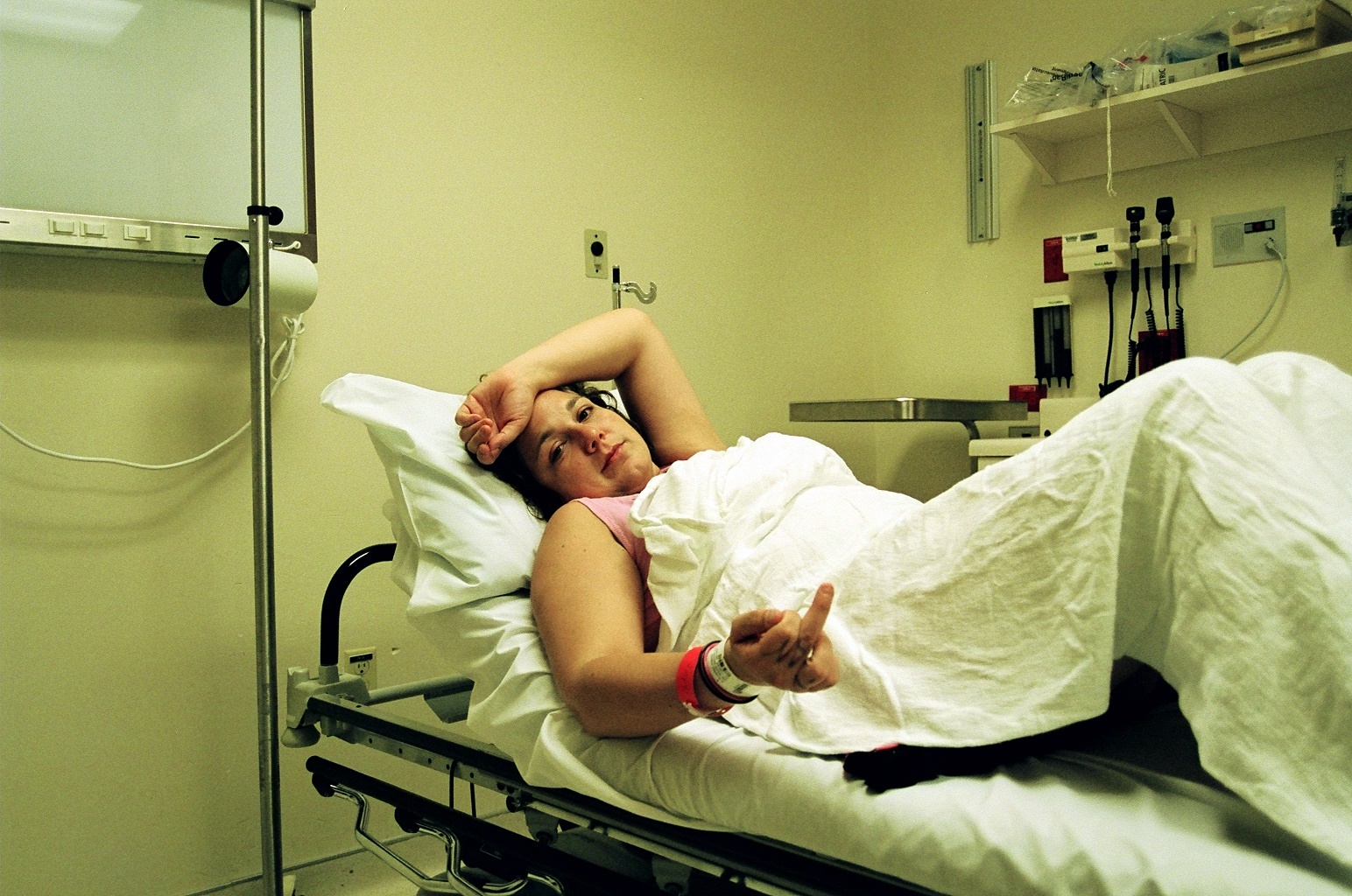 a woman laying in a hospital bed in a room