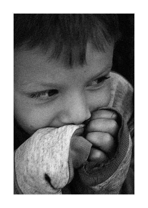 a black and white pograph of a boy biting into soing