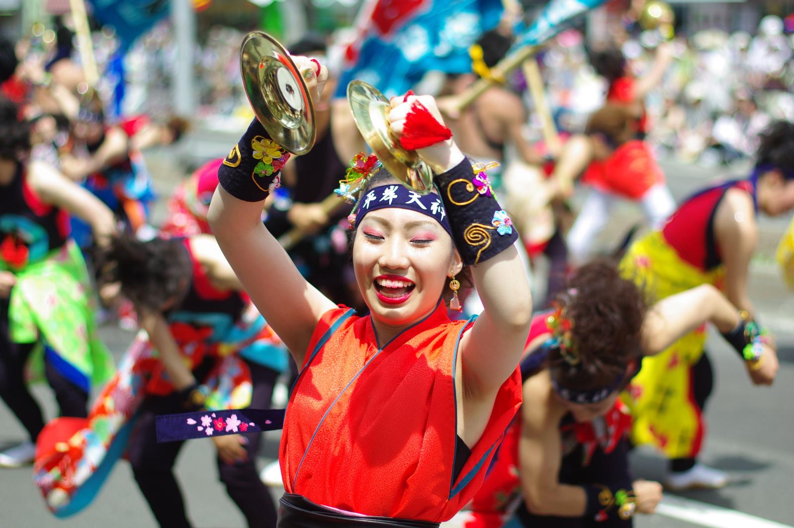 an asian woman in a parade holding a ss dish