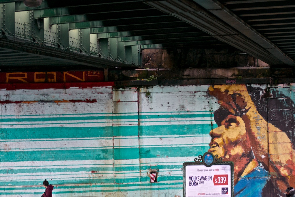 a wall under an overpass with a large mural