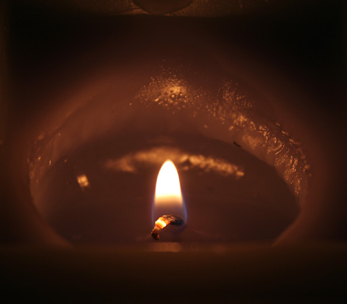 a candle is lit with a dark background