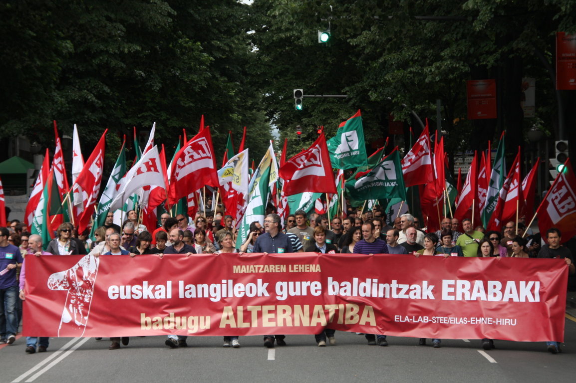 a large crowd is in front of a flag banner that says euska laninglooke