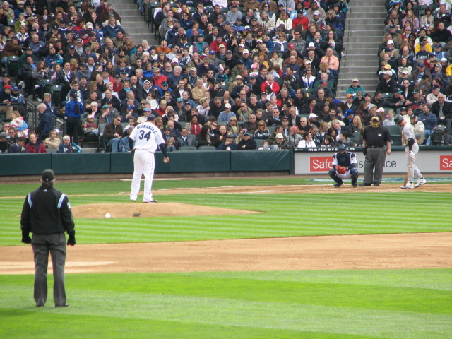 a man is standing on the pitchers mound watching a game