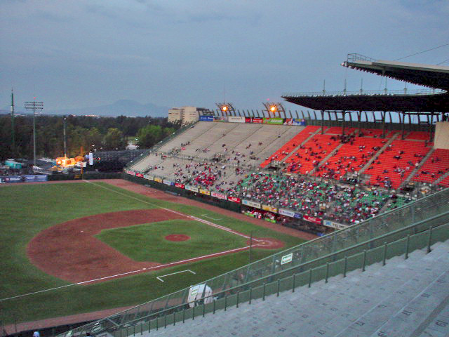 an empty baseball stadium with a batter at the back