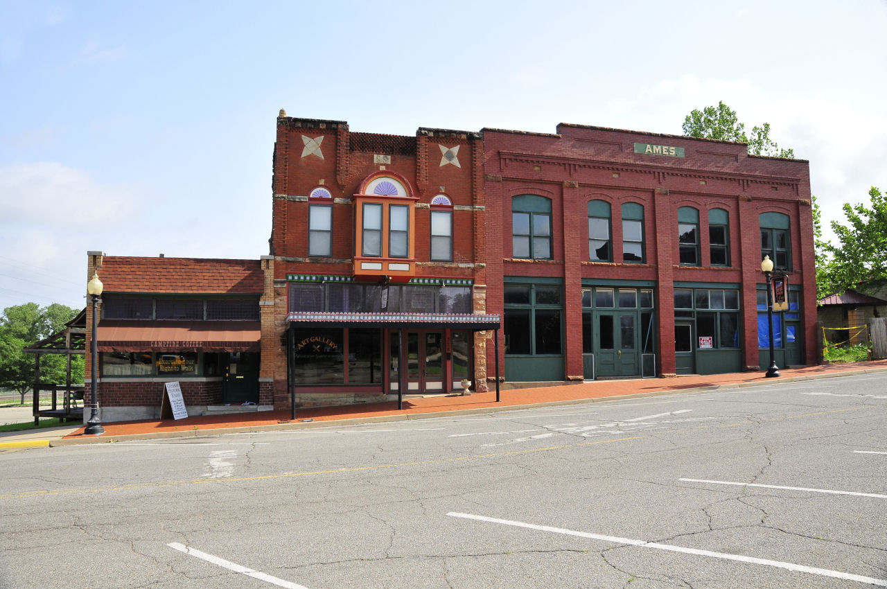 an old western town with store fronts, and two brick buildings
