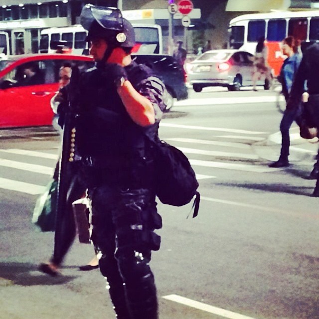 a person in the street wearing a riot gear and holding a bag