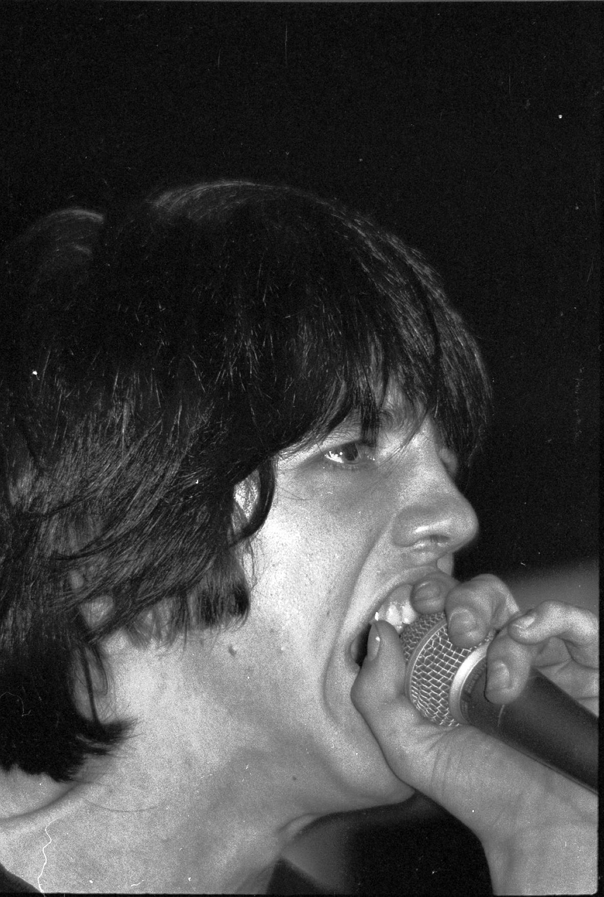 a man is screaming and holding a microphone up in the air