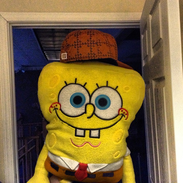 spongebob wearing a red hat and orange pants on the front door