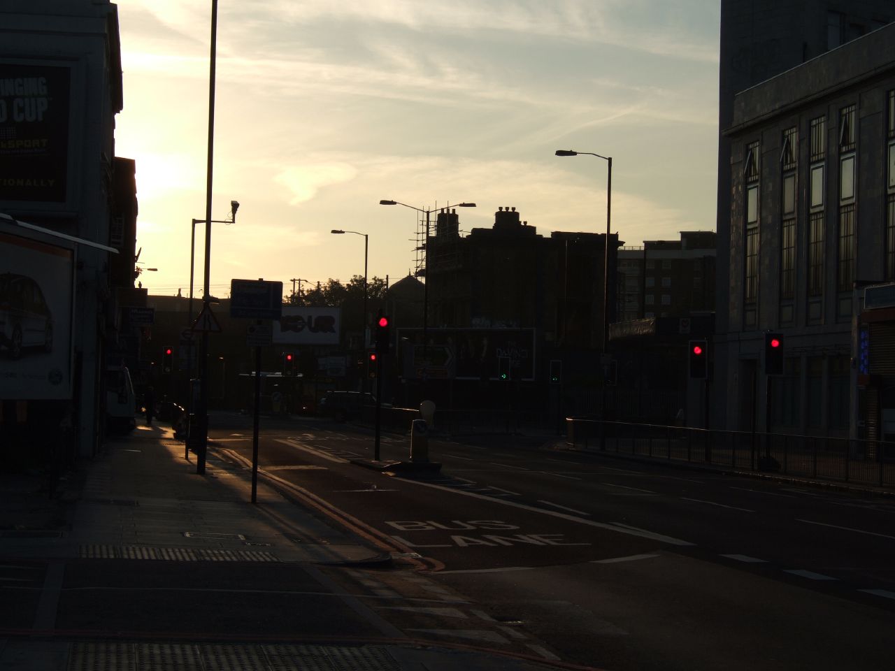 the sun rising behind a busy city street