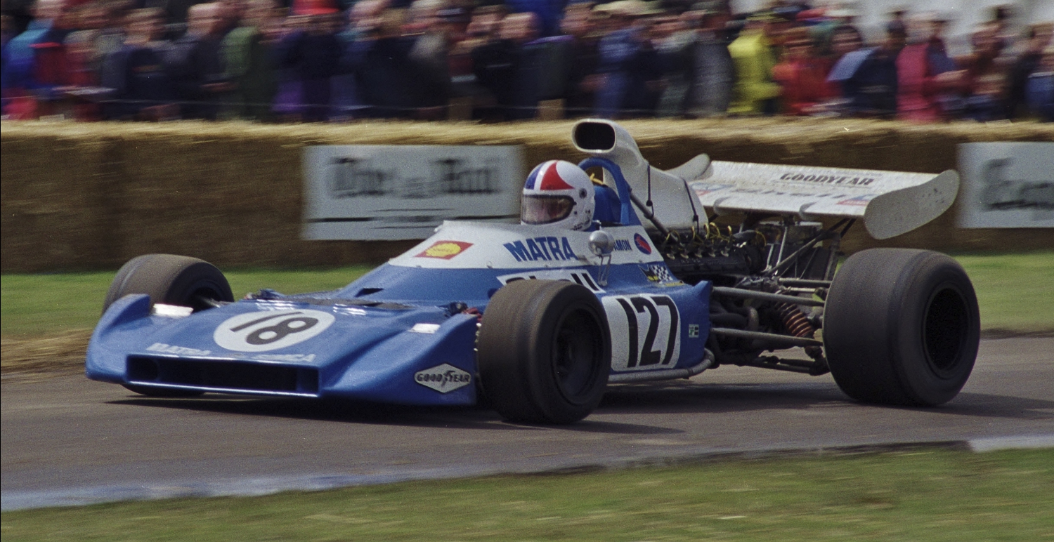 a man racing on top of a race car