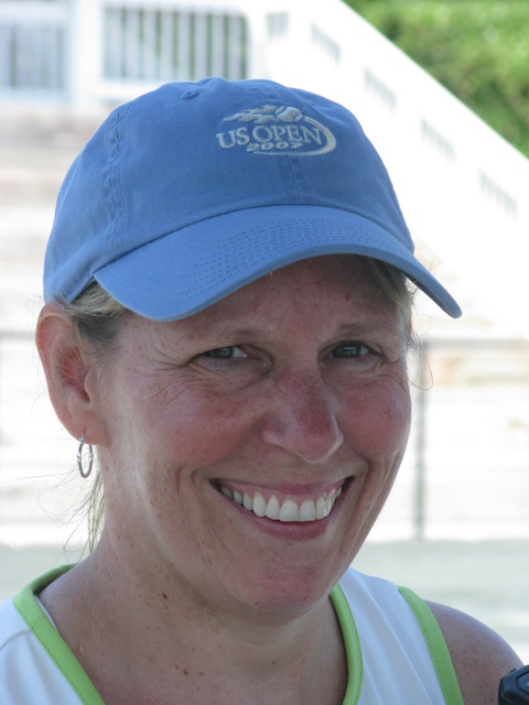 a close up of a woman in a blue hat smiling
