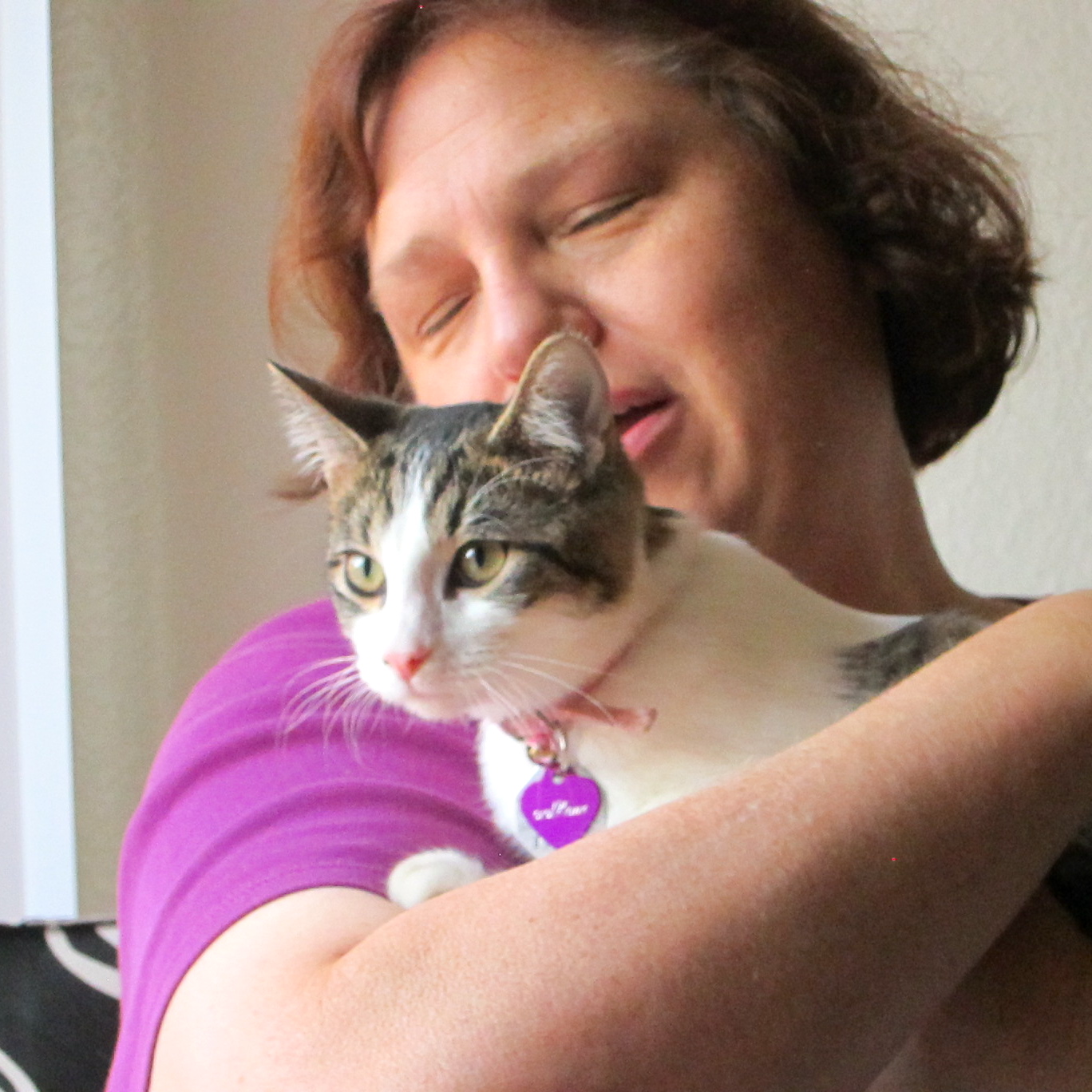 a woman holds her cat while taking a po